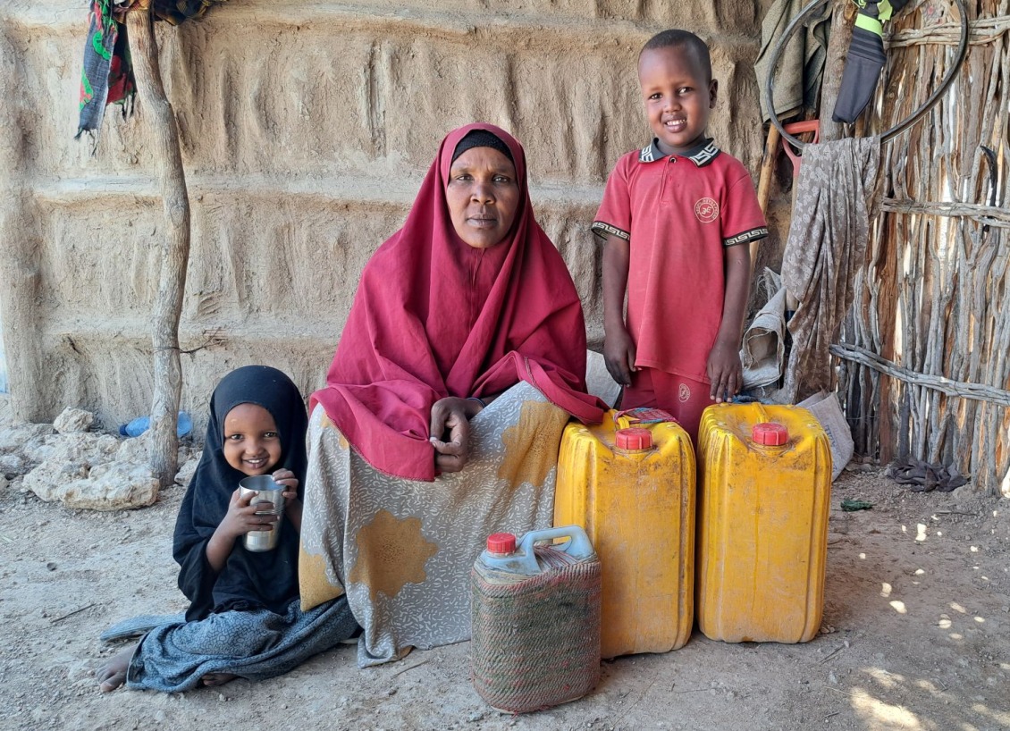 Salaado and her children with jerry cans of clean water.