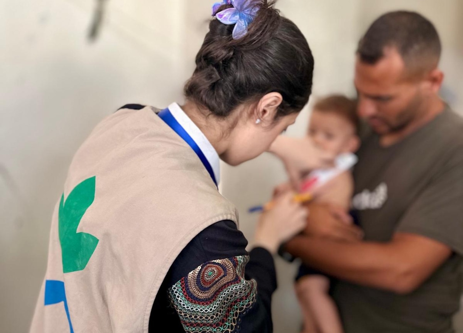 Health worker screens a child for severe malnutrition in Gaza.