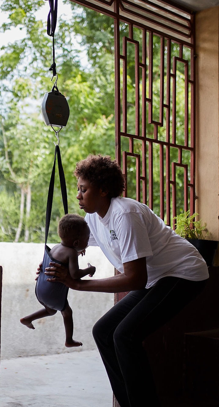 At a health clinic, a child is weighed and screened for malnutrition. Right now, millions of people in Haiti - many of them children - face a serious hunger crisis.