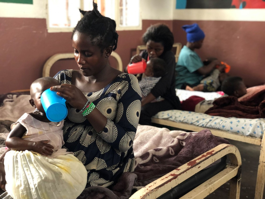 Caregivers give their children therapeutic milk at a stabilization center in the Democratic Republic of Congo.