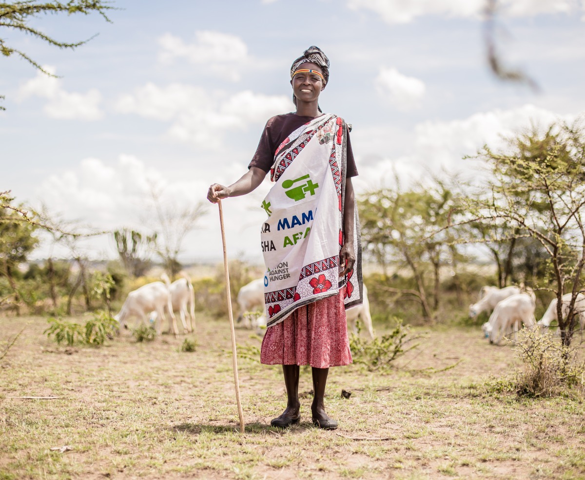 A member of one of Action Against Hunger's mother-to-mother support groups stands in front of her livestock.