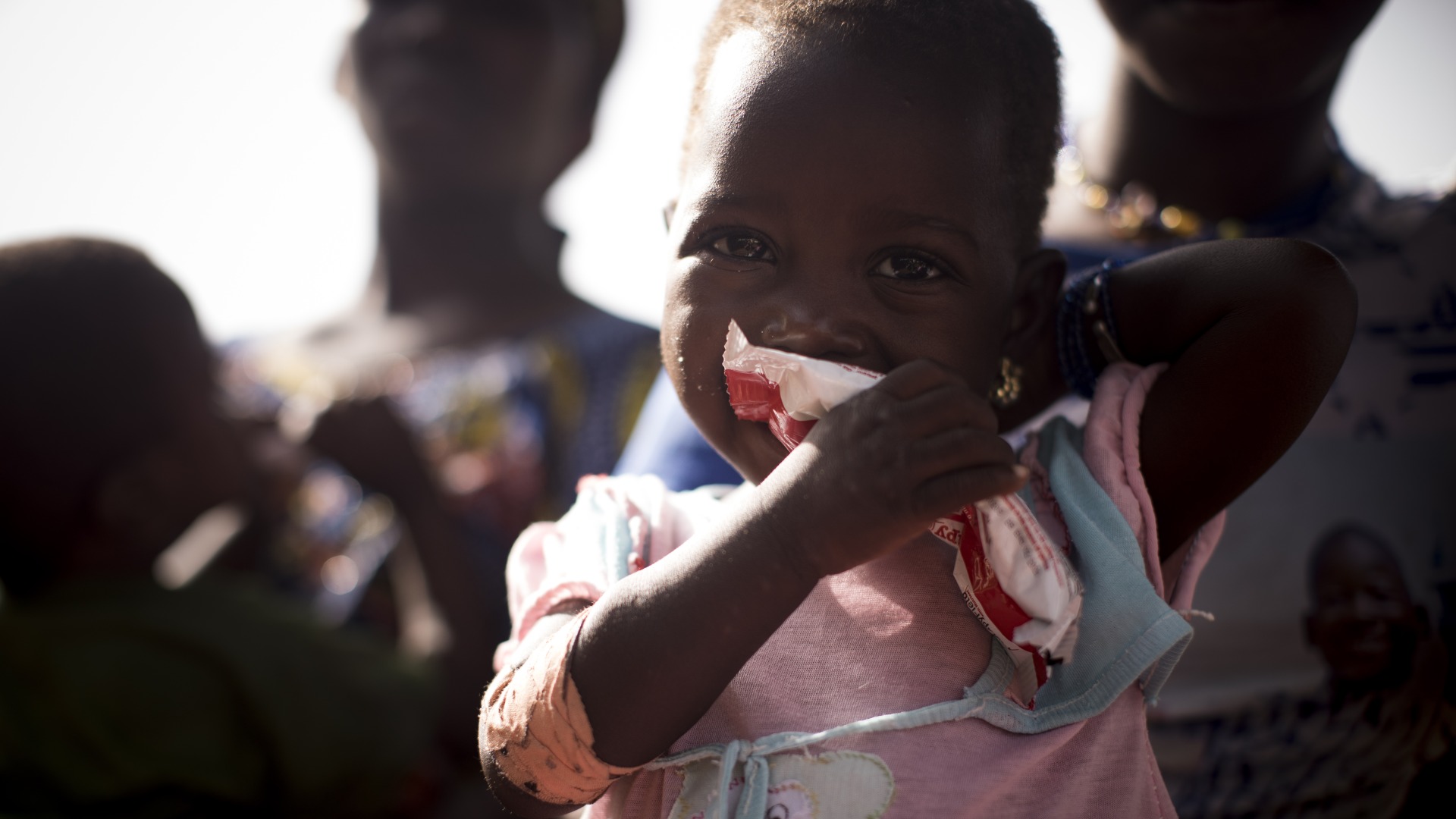 A girl eats Plumpy'Nut, the lifesaving ready-to-use therapeutic food that will help her recover from malnutrition.