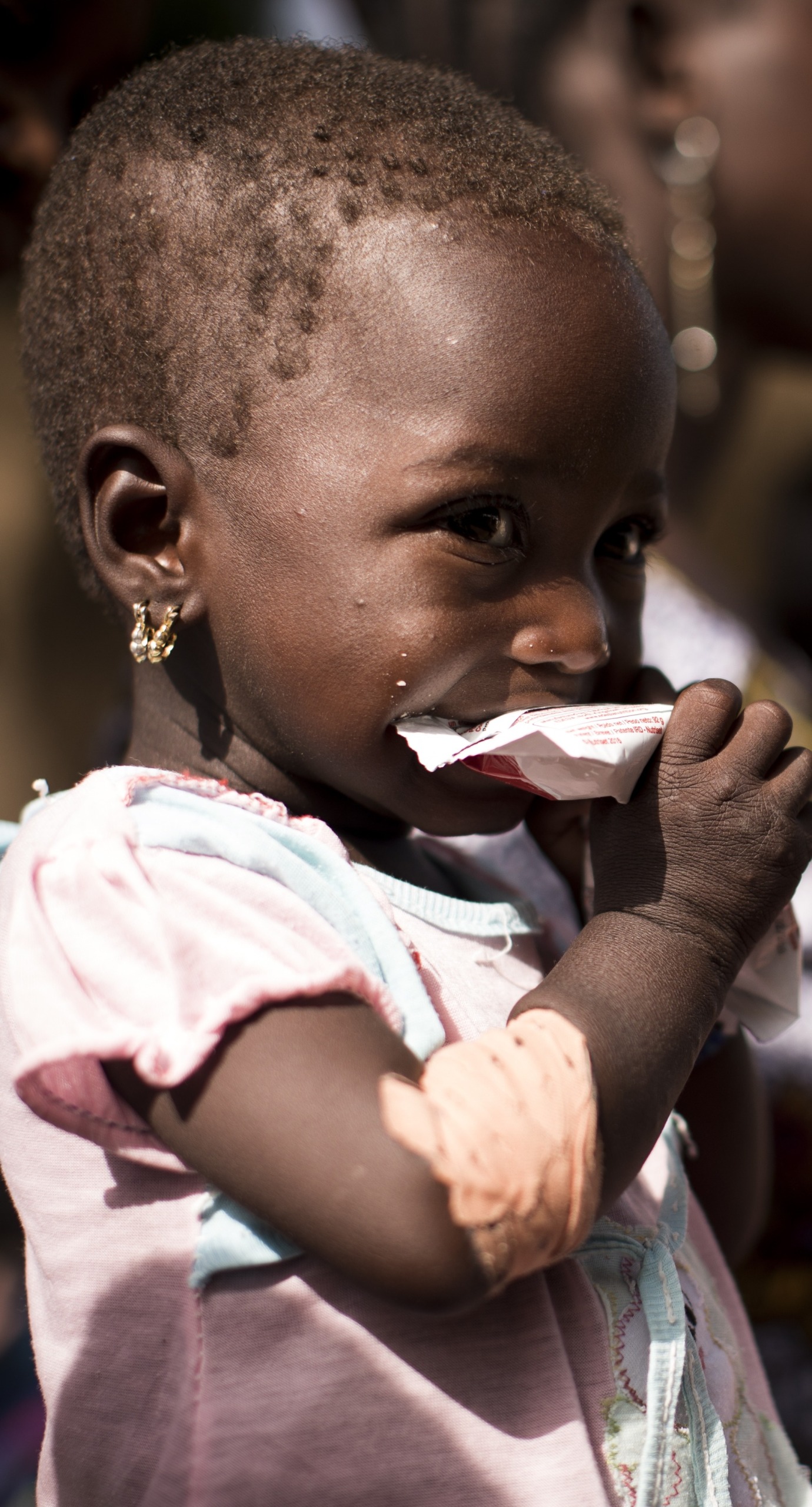 A girl eats Plumpy'Nut, the lifesaving ready-to-use therapeutic food that will help her recover from malnutrition.