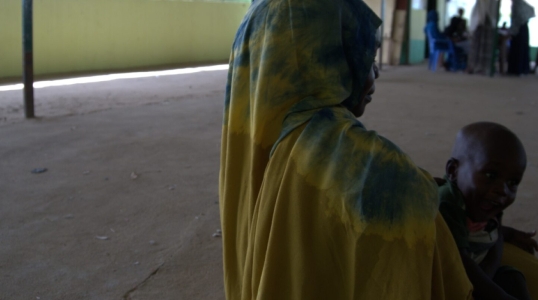 A 27-year-old mother and seasonal farmer receives RUTF and medicine for her child from a health facility.