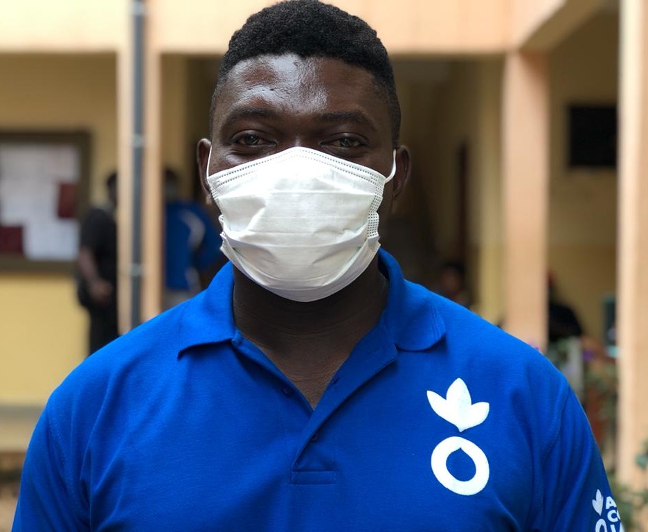 An Action Against Hunger aid worker in a mask looks at the camera.