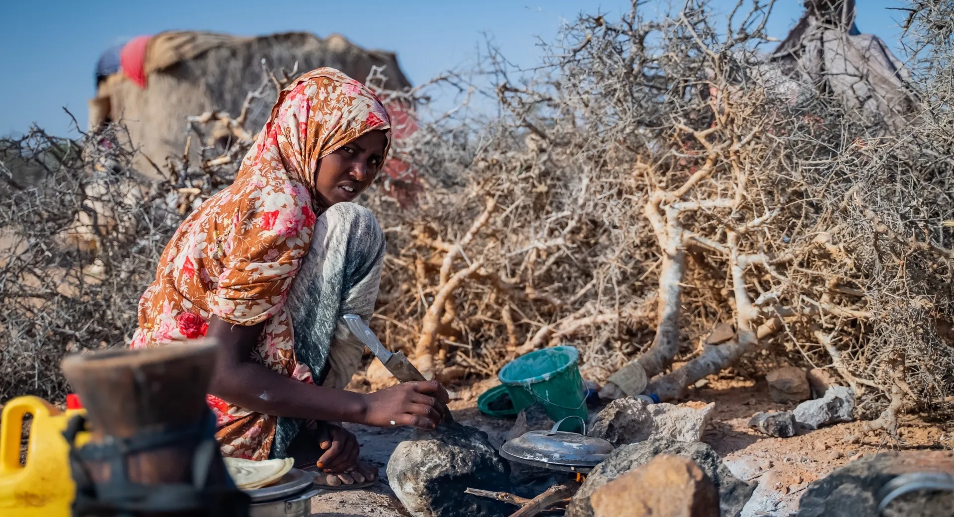 A girl, 16, makes breakfast for her family in a drought in Somalia.