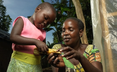Judith shows her daughter corn she grew.