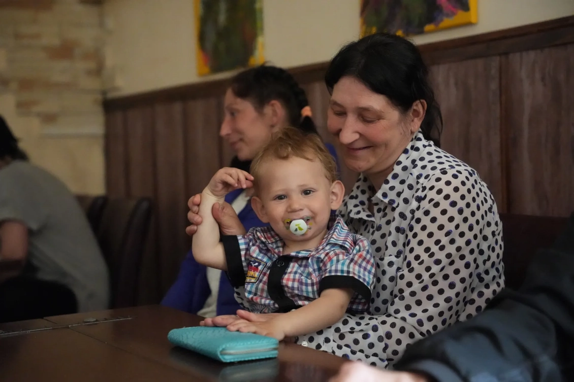 A woman holds a baby with a binky in his mouth in Dnipro, Ukraine.