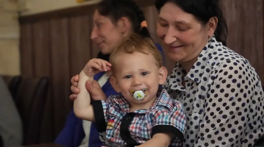 A woman holds a baby with a binky in his mouth in Dnipro, Ukraine.